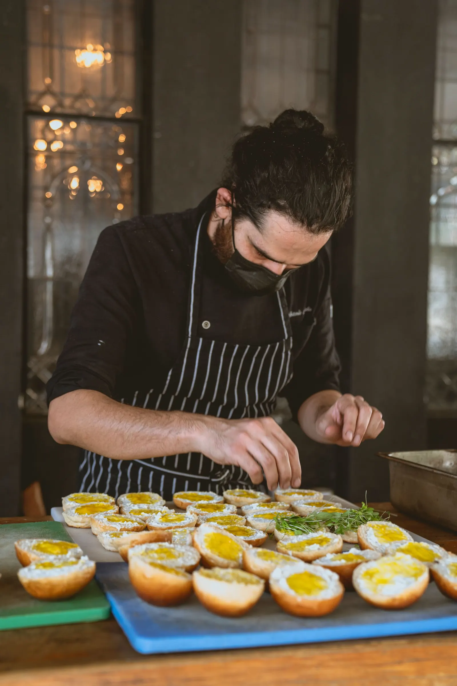 A cook plating food at a kitchen counter