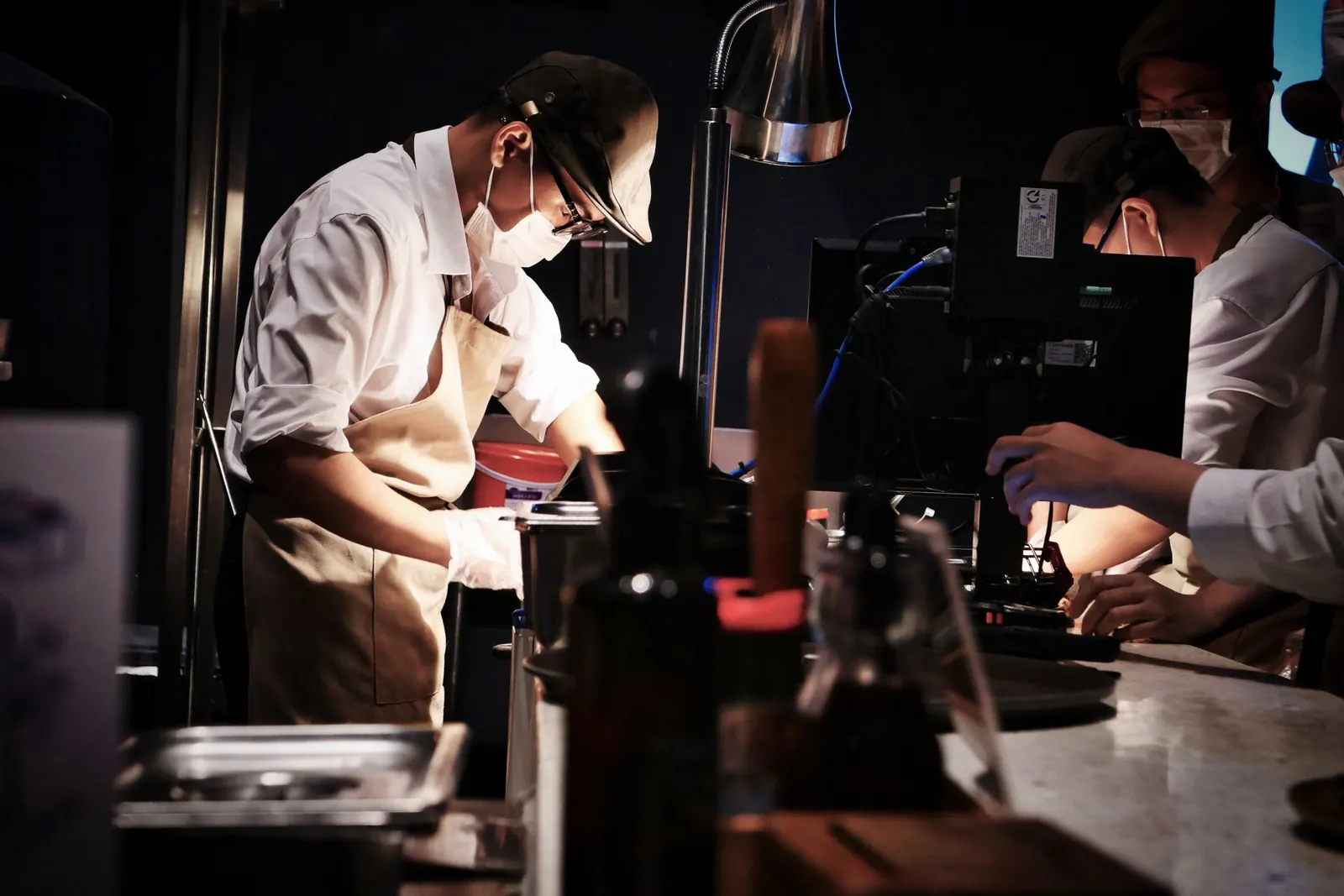 Chefs preparing dishes at the pass of a restaurant kitchen